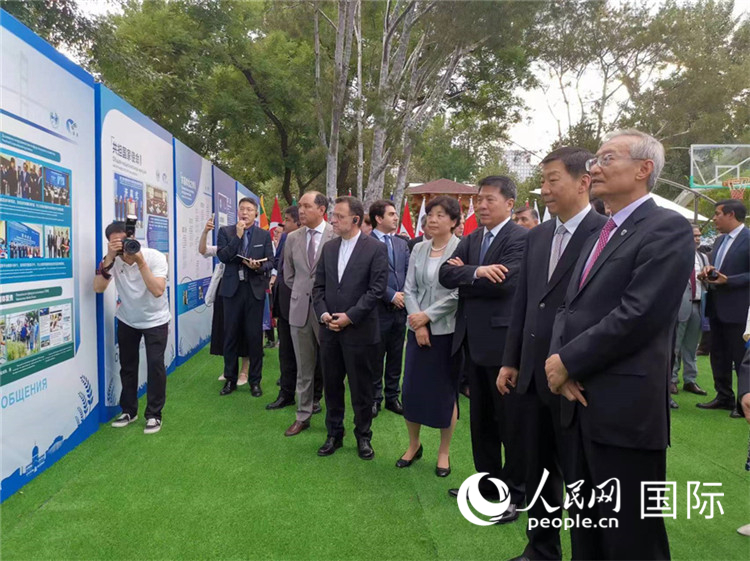 上合组织秘书长张明与来宾参观杨凌示范区成立五周年成果图片展。人民网记者杨倩 摄